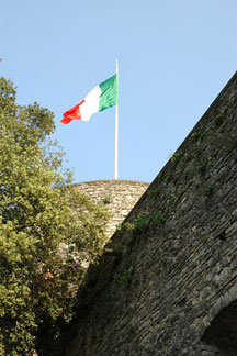 Italian flag flying on a historic tower in Bergamo